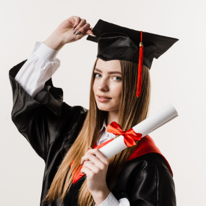 A graduate in a black cap and gown holds a diploma tied with a red ribbon, celebrating their academic achievement.